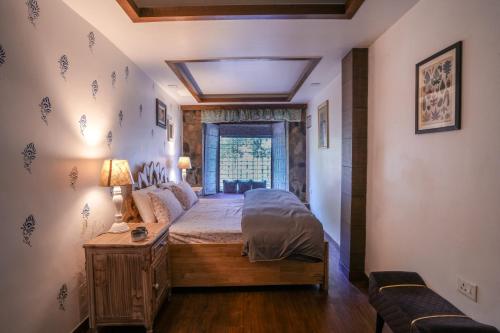a bedroom with a bed and a window at Woodburry Mansion, Cozy Nainital Homestay in Nainital