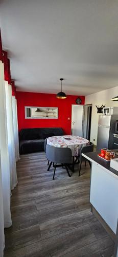 - un salon avec un lit et un mur rouge dans l'établissement Appartement 2 chambres centre Tarascon-sur-Ariège, à Tarascon-sur-Ariège