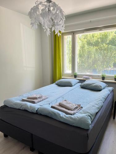 Una cama grande en una habitación con una ventana grande. en Quietly located one-bedroom apartment near downtown, en Jyväskylä