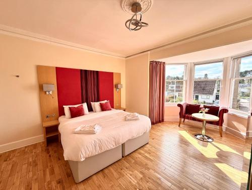 a bedroom with a large bed with a red headboard at The Clubhouse Nairn in Nairn