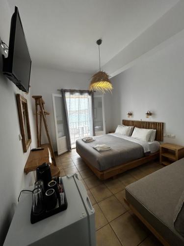 a bedroom with a bed and a tv in a room at Hotel Livadia in Parikia