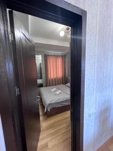 a door leading into a bedroom with a bed at კომფორტული ბინა ცენტრში in Kutaisi Heliport