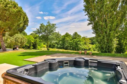 une baignoire jacuzzi dans l'arrière-cour d'une maison dans l'établissement L'Atrie-Villa Piscine - Jacuzzi - Sauna, à Aizenay
