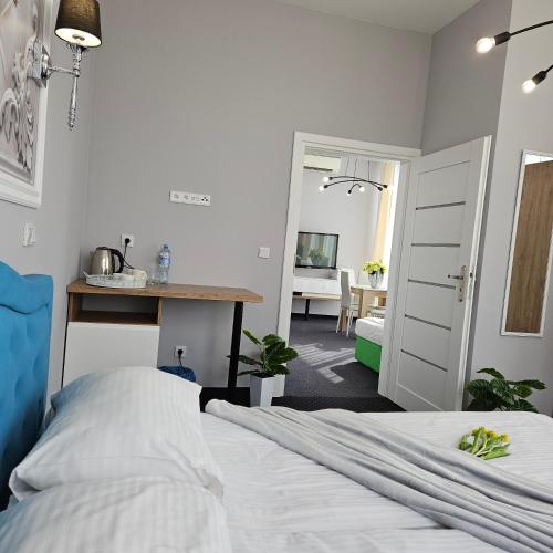 a bedroom with a bed and a desk and a table at Aquila Hotel in Zator
