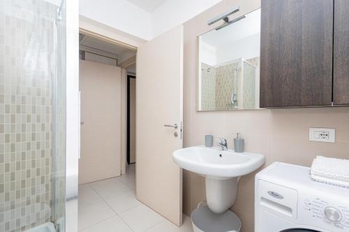 a white bathroom with a sink and a mirror at Accogliente e moderno appartamento in zona Ospedali & Stazione in Pavia
