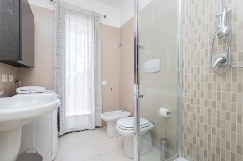 a bathroom with a toilet and a sink and a shower at Accogliente e moderno appartamento in zona Ospedali & Stazione in Pavia