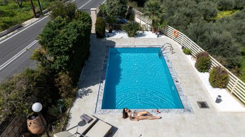 an overhead view of a swimming pool with two women laying in front at Villa Althaea in Loutra