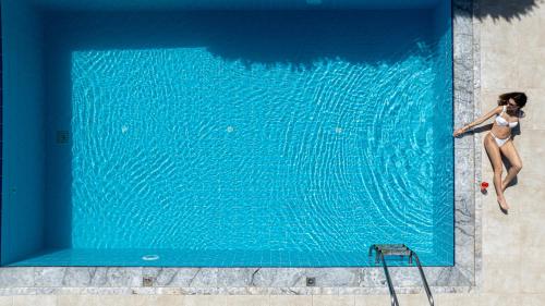 a woman in a bikini standing in a swimming pool at Villa Althaea in Loutra