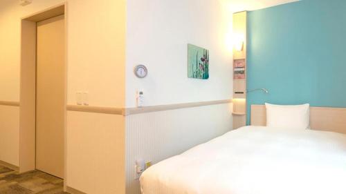 a bedroom with a white bed and a mirror at Toyoko Inn Tottori-eki Minami-guchi in Tottori