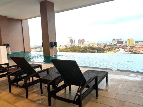 a room with chairs and a view of the water at The Apple Melaka in Melaka
