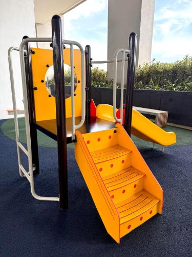 a playground with yellow and orange swings at The Apple Melaka in Melaka