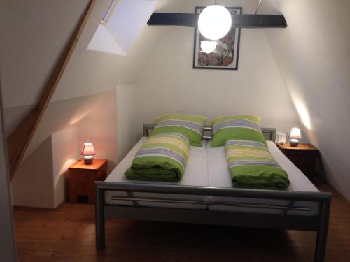 a bedroom with a bed with green pillows at Lübecker Ganghausperle in Lübeck