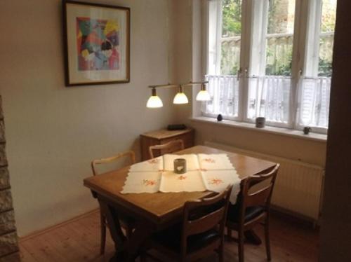 a dining room with a table with chairs and windows at Lübecker Ganghausperle in Lübeck