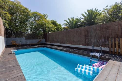 a swimming pool with two lounge chairs in a backyard at Liiiving in Porto - Pool Paradise Apartments in Porto