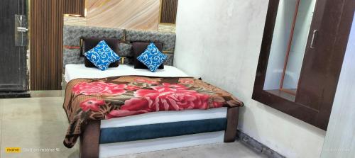 a bedroom with a bed with red flowers on it at Hotel Aniruddha palace in Mathura