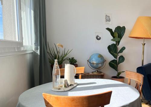 une table à manger avec une bouteille et des chaises dans l'établissement Panoramic view - Bright and cosy flat - 6 guests, à Paris