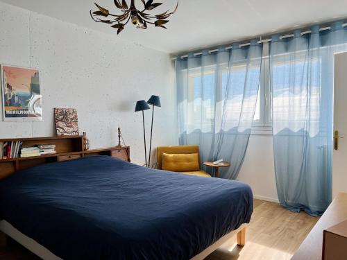 - une chambre avec un lit bleu et une chaise dans l'établissement Panoramic view - Bright and cosy flat - 6 guests, à Paris