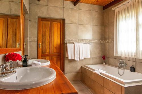 a bathroom with a tub and a sink and a tub and a tub at Bakenskraal Ostrich Palace in Oudtshoorn