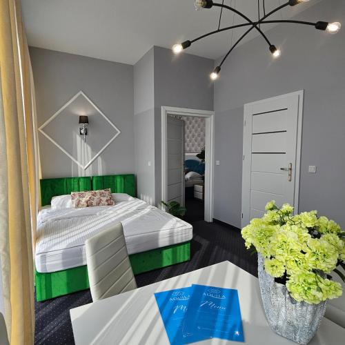 a bedroom with a bed with a green headboard at Aquila Hotel in Zator