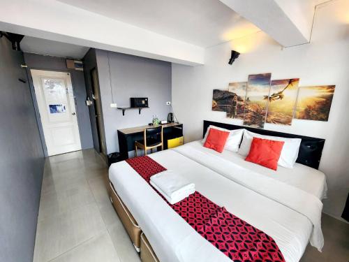 a bedroom with a large bed with red pillows at Khaosan Art Hotel in Bangkok