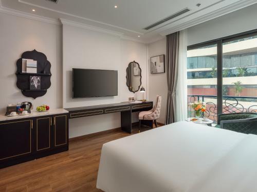 a bedroom with a bed and a desk and a tv at Cloud 22Land hotel in Hanoi