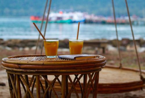 two glasses of orange juice sitting on a table at Koalama Cambodia in Koh Rong Sanloem