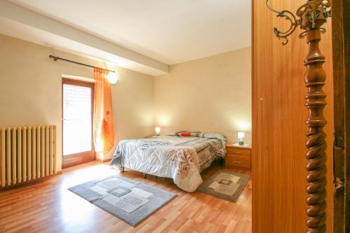 a bedroom with a bed and a large window at La Ghiacciaia in Verzuolo