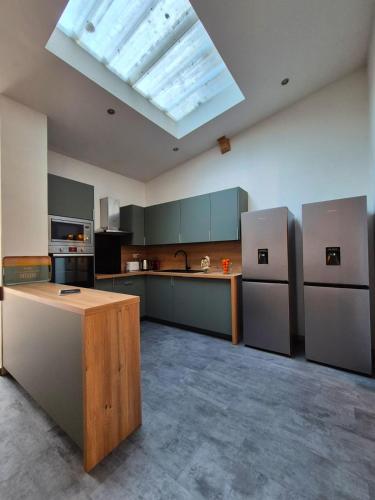 une grande cuisine avec une lucarne au plafond dans l'établissement Le Repère Maison avec jardin, à Tourcoing