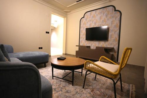 a living room with a couch a table and a tv at شقق ماي هوم 2 in Al Madinah