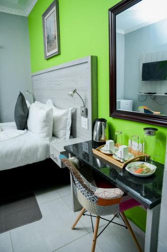 a bedroom with a bed and a desk with a mirror at Same Stay Inn in Francistown