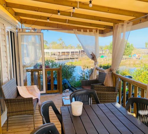 - une terrasse couverte avec une table et des chaises dans l'établissement Mobilhome 8 personnes cosy tout équipé avec vue sur bassin, cap ferret, à Lège-Cap-Ferret