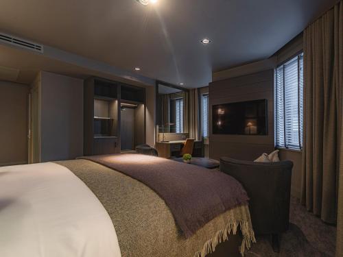 a bedroom with a large bed and a chair at Dakota Newcastle in Newcastle upon Tyne
