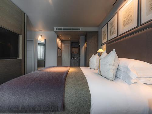 a bedroom with a large bed with white pillows at Dakota Newcastle in Newcastle upon Tyne