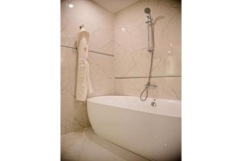a white bath tub in a bathroom with marble walls at Sunday Emerald Hotel in Jeddah