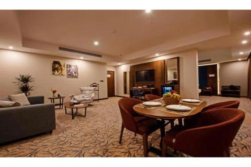 a living room with a table and a couch at Sunday Emerald Hotel in Jeddah