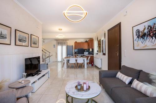 a living room with a couch and a table at Villa Althaea in Loutra