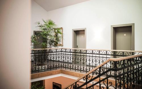 a staircase in a building with a wrought iron railing at Boutique & Gourmet Hotel Orso Grigio in San Candido