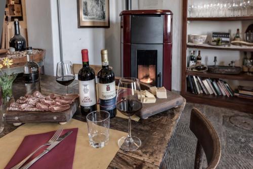 a table with two bottles of wine and wine glasses at Agriturismo La Fattoria di Capezzana in Carmignano