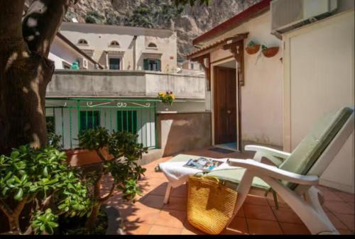 a patio with a chair and a table and a building at Secret Garden Amalfi Coast in Atrani