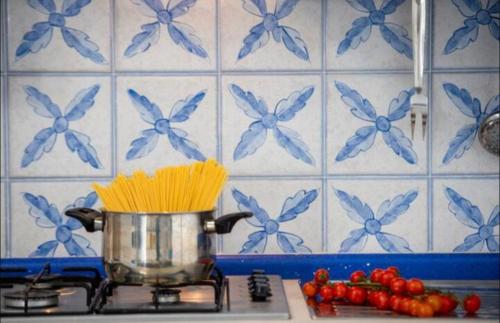 a pot on a stove with some spaghetti squash and tomatoes at Secret Garden Amalfi Coast in Atrani