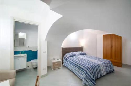a bedroom with a bed and a bathroom with a sink at Secret Garden Amalfi Coast in Atrani