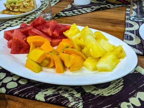 un piatto bianco di frutta su un tavolo di Ultra Home Hostel ad Arusha