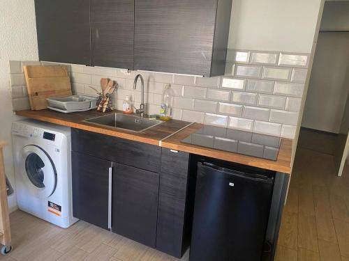 une cuisine avec un évier et une machine à laver dans l'établissement Cozy and modern studio, à La Grande Motte