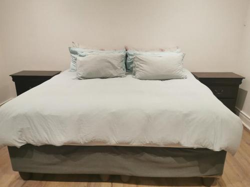a large bed with white sheets and pillows at 29 on Edward - 4 bedroom House in Cape Town