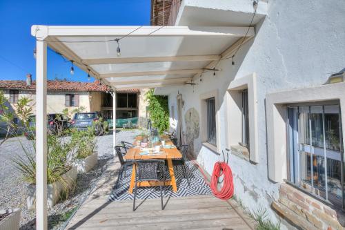 a patio with a table under a white pergola at In Bocca Al Lupo with Shared Pool in Clavesana