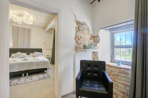 a bedroom with a bed and a black chair at In Bocca Al Lupo with Shared Pool in Clavesana