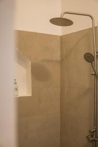 a shower with a shower head in a bathroom at Oxygen Paje Hotel in Paje