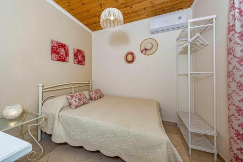 Habitación pequeña con cama y techo de madera. en Leni's Lake Living, en Halikounas