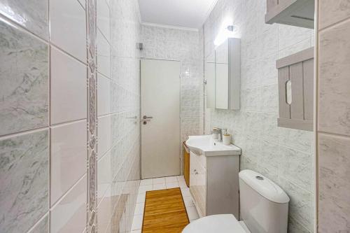 Un baño blanco con inodoro y lavabo. en Leni's Lake Living, en Halikounas