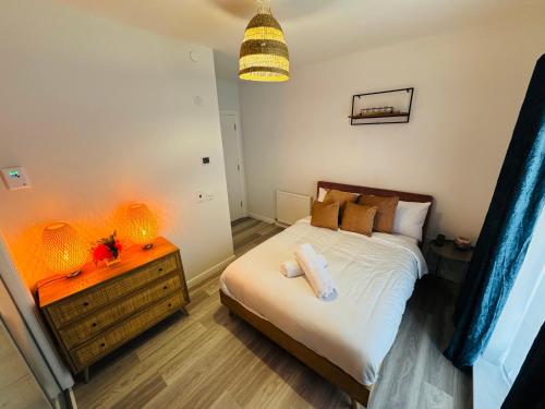 a bedroom with a bed and a nightstand with lights at Modern Flat in Glasgow City FREE Parking & Wifi in Glasgow